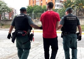 Dos guardias civiles con el preso fugado tras su detención en Barcelona.