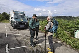 tEl cabo primero Sergio Antuña y la guardia Cristina González conversan con un peregrino en la zona de la Concha de Artedo.