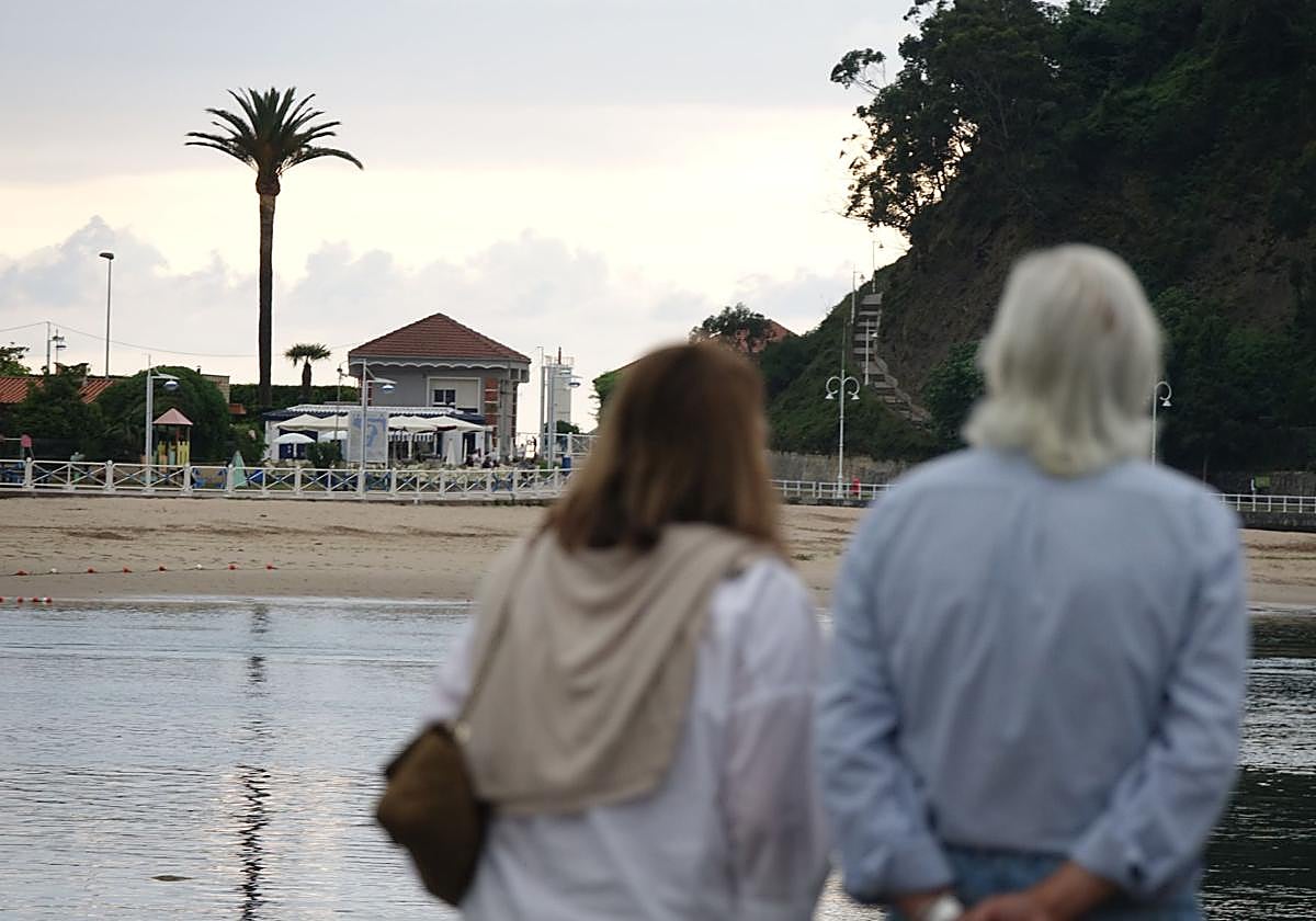Una pareja observa la playa de Ribadesella.