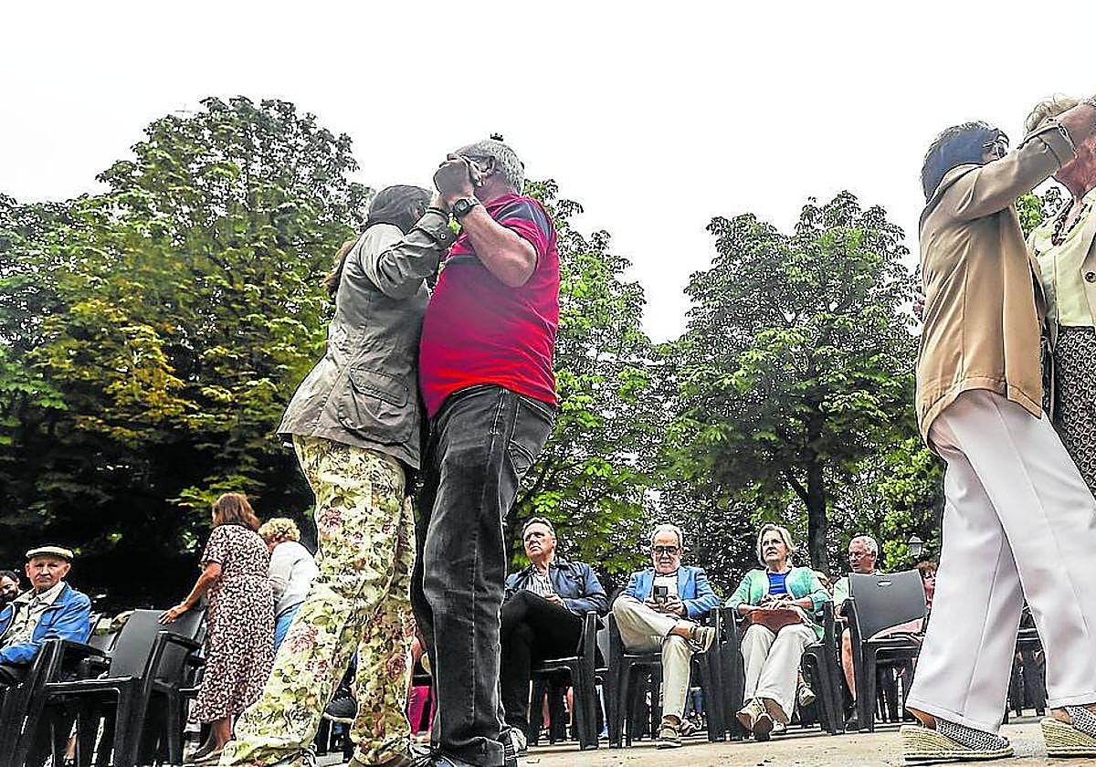 Dos parejas bailan una pieza en el paseo del Bombé delCampo mientras otrossiguen sentados.