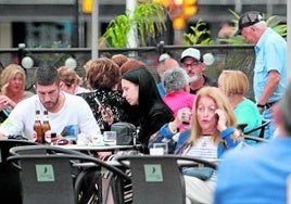 Clientes consumen en la terraza de un negocio de hostelería de Gijón.