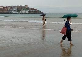 Dos mujeres pasean este martes por la playa de San Lorenzo de Gijón.