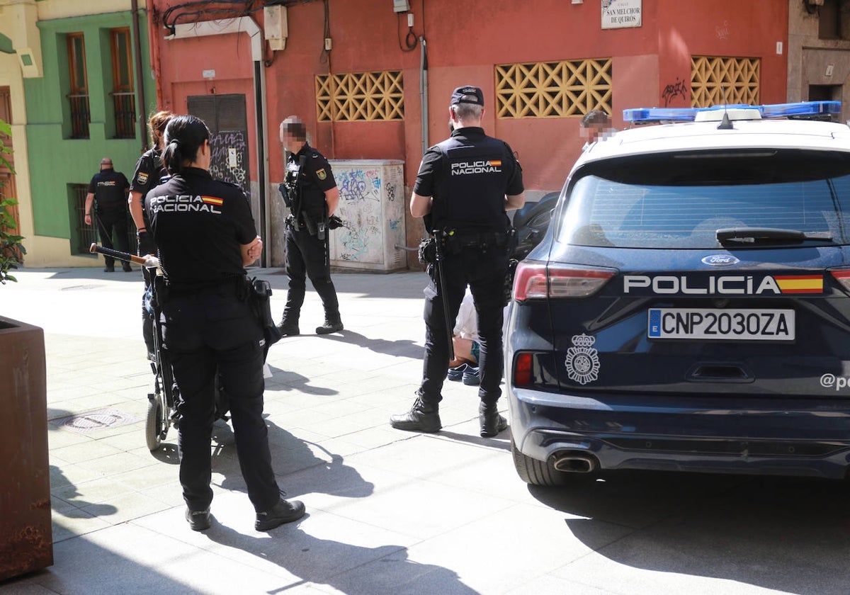 Agentes de la Policía Nacional custodian al detenido, en presencia de su padre, que iba en silla de ruedas, donde llevaba el cuchillo y el bate de béisbol (en la imagen).