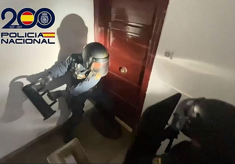 Momento en el que agentes de la Policía Nacional fuerzan la puerta de la casa donde se escondían los arrestados, así como el material robado.