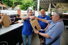 Unos vecinos recibiendo el bollo y el vino en Salinasa.