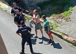 El presunto agredido sin camiseta explica a los agentes su versión de los sucedido con su vecino.