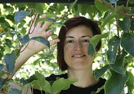 Cristina Secades con los mini kiwis, que nacen en racimoscomo las uvas, que está a punto de cosechar.