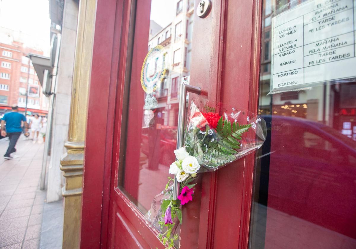 Flores en recuerdo de Carlos García Rubio y Maribel Alberti en una de las entradas al bar El Cafetón.