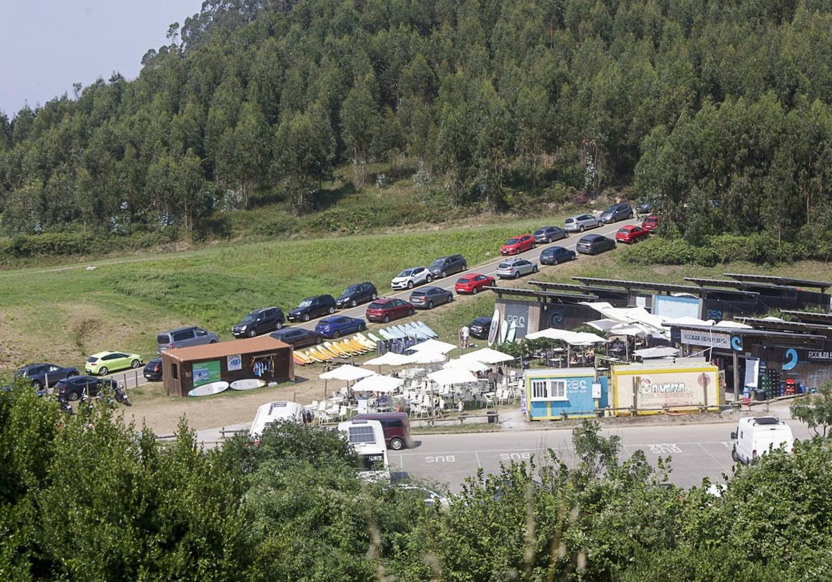 Coches aparcados en el arcén de la carretera de acceso a la playa de Rodiles.