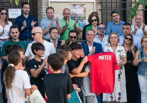 Amigos del niño asesinado muestran una camiseta con su nombre durante el minuto de silencio que se guardó en Mocejón, Toledo.