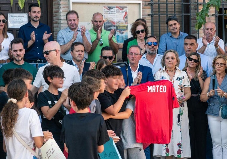 Amigos del niño asesinado muestran una camiseta con su nombre durante el minuto de silencio que se guardó en Mocejón, Toledo.