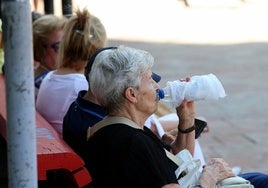 Una señora bebe agua en un banco del centro de Oviedo, en la última ola de calor que azotó Asturias.