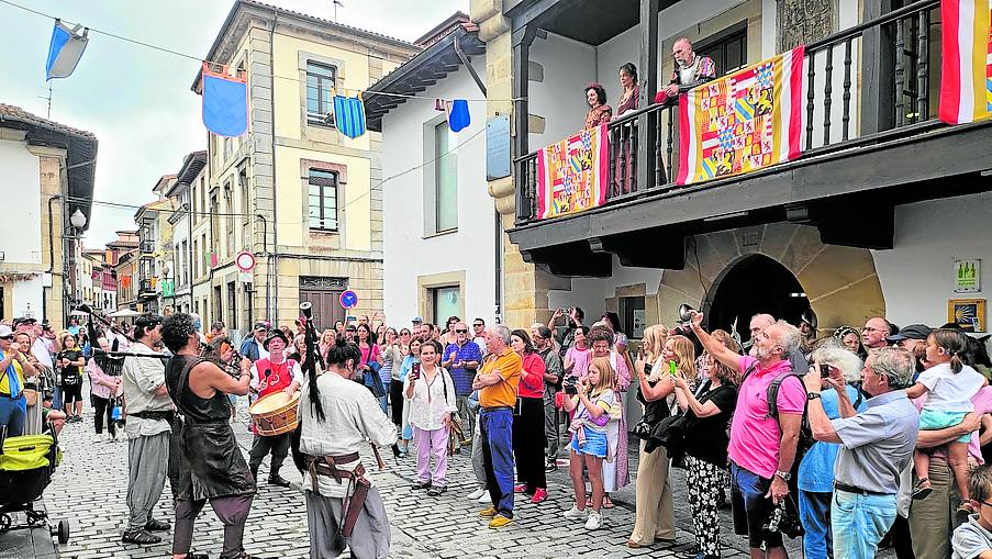 Desde el balcón, miembros de la comitiva real observan a los músicos