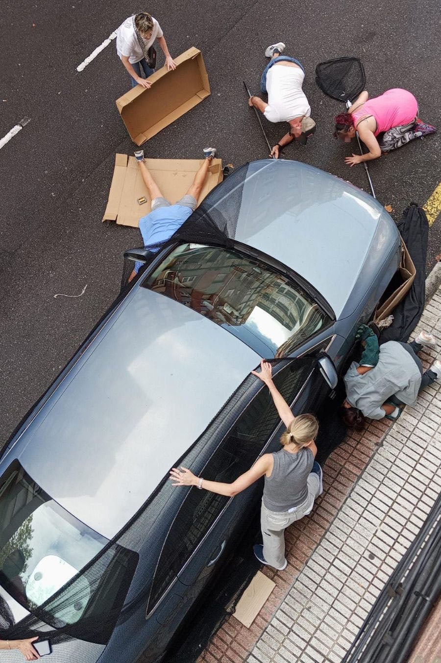 Los vecinos intentan recuperar al gato que se encontraba debajo de un coche.