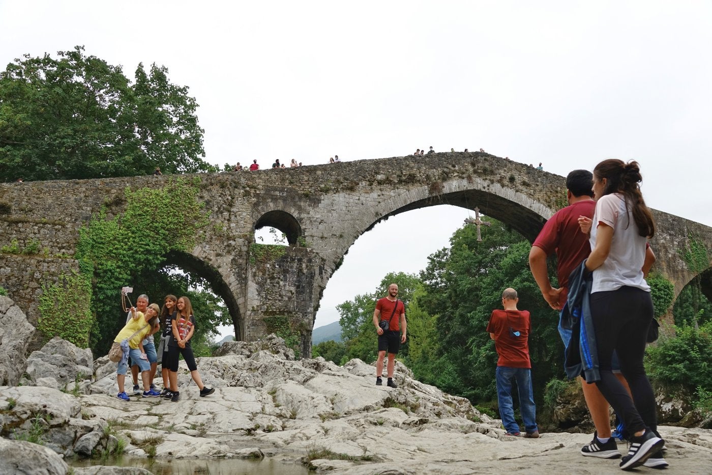 Turistas disfrutando de uno de los iconos más emblemáticos de Asturias, el 'Puente Romano' de Cangas de Onís.