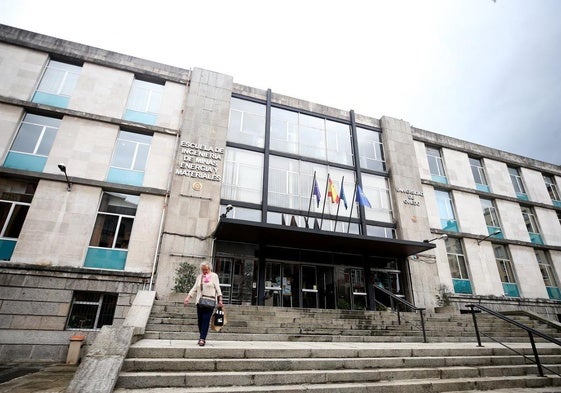 Una mujer baja por las escaleras de la entrada principal a la Escuela de Minas de Oviedo