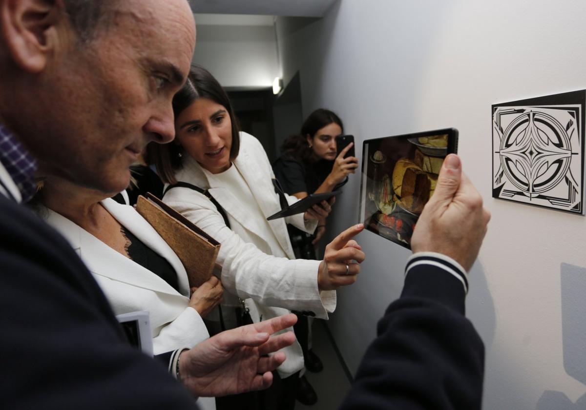 Pablo León observa en la tableta una obra de Clara Peeters y atiende a las explicaciones de la comisaria, Begoña Torre.