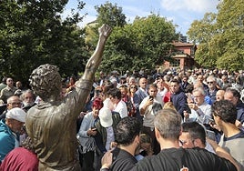 Aficionados e invitados tratan de hacerse una fotografía con la estatua de Quini al término del acto.