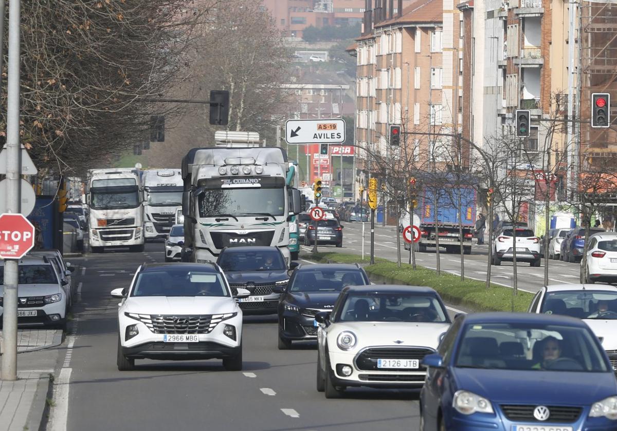 Tráfico denso en la avenida del Príncipe de Asturias, con varios camiones transitando por pleno barrio de La Calzada.