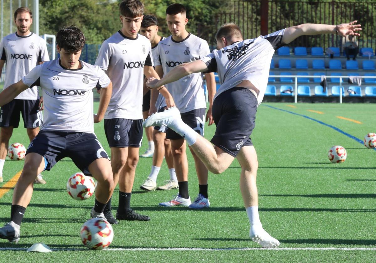 Los juveniles Dani y Macías, en primer plano en el entrenamiento del Avilés ayer en La Toba.