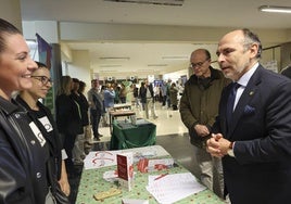 El rector departe con dos jóvenes en uno de los stands de la Feria del Voluntariado.