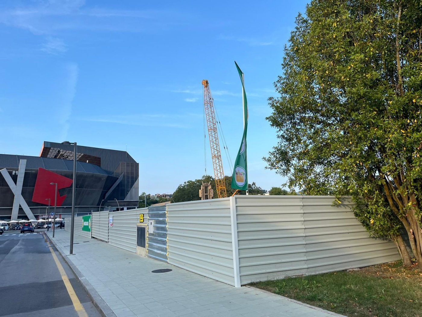 Obra del Mercadona frente a El Molinón, con la banderola de la compañía.