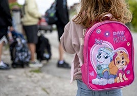 Una niña espera el transporte escolar.