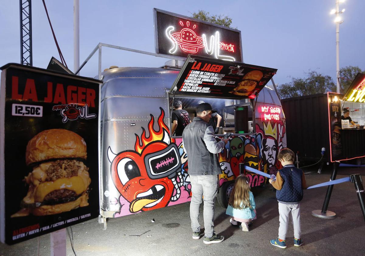 Una familia hace cola en uno de los puestos de hamburguesas de 'The Champions Burger'.