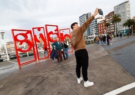 Un grupo de turistas se hace un selfie en 'Las letronas', en el Puerto Deportivo de Gijón.