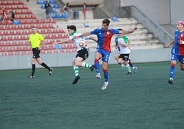 Juan López, del Langreo, pelea un balón con el santanderino Diego Díaz, del Rayo Cantabria.