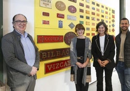 Javier Fernández, director del Museo del Ferrocarril de Asturias, con Nuria Vila, Montserrat López y Aitor Martínez, con algunas placas tras ellos.