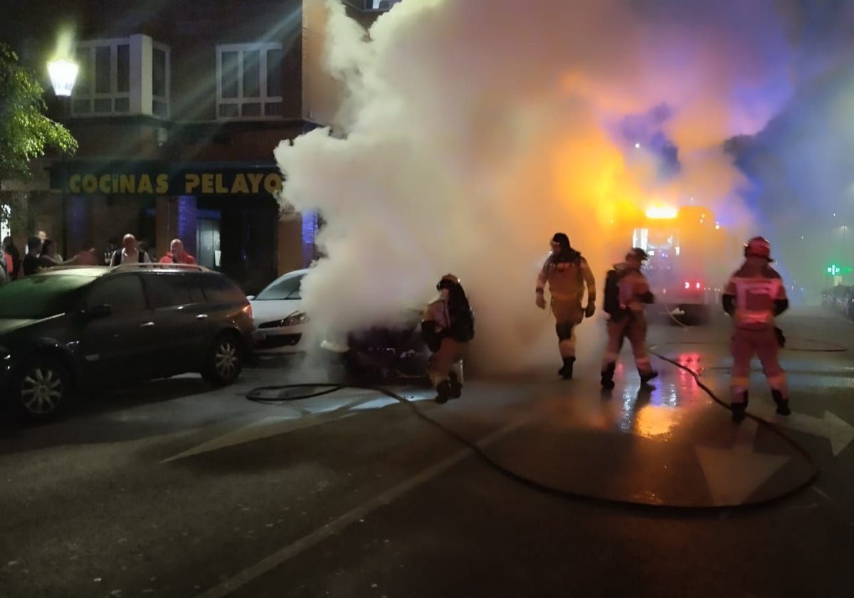 Los bomberos sofocan el incendio de un coche en la calle Eleuterio Quintanilla.