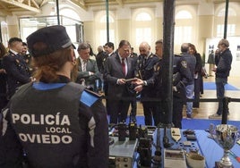 El alcalde observa uno de los objetivos de la exposición en Trascorrales en pesencia de Prado, Cuaendias y Lozano.