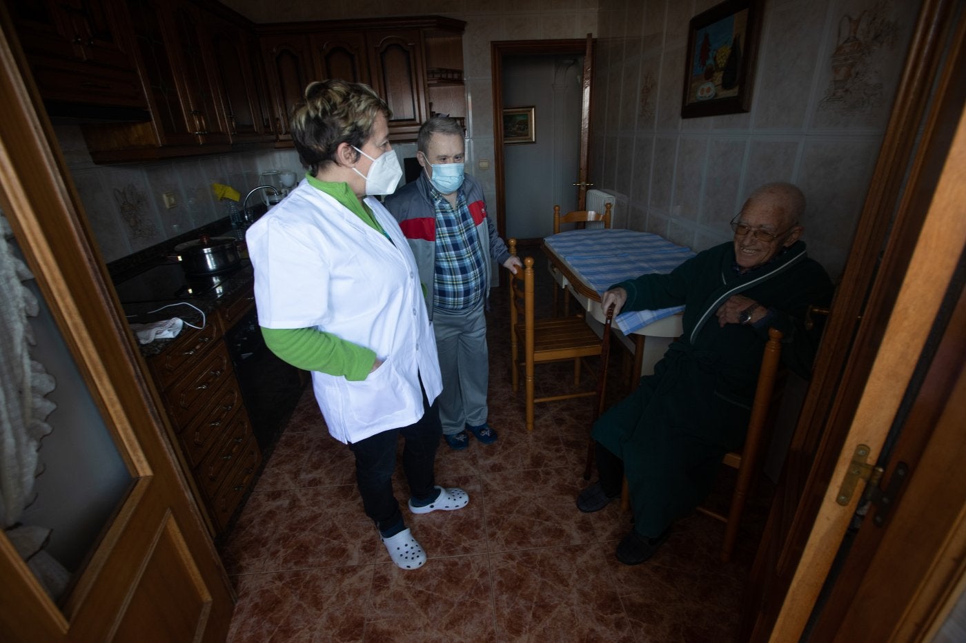 Una trabajadora del servicio de ayuda a domicilio de Avilés con las dos personas que atiende.