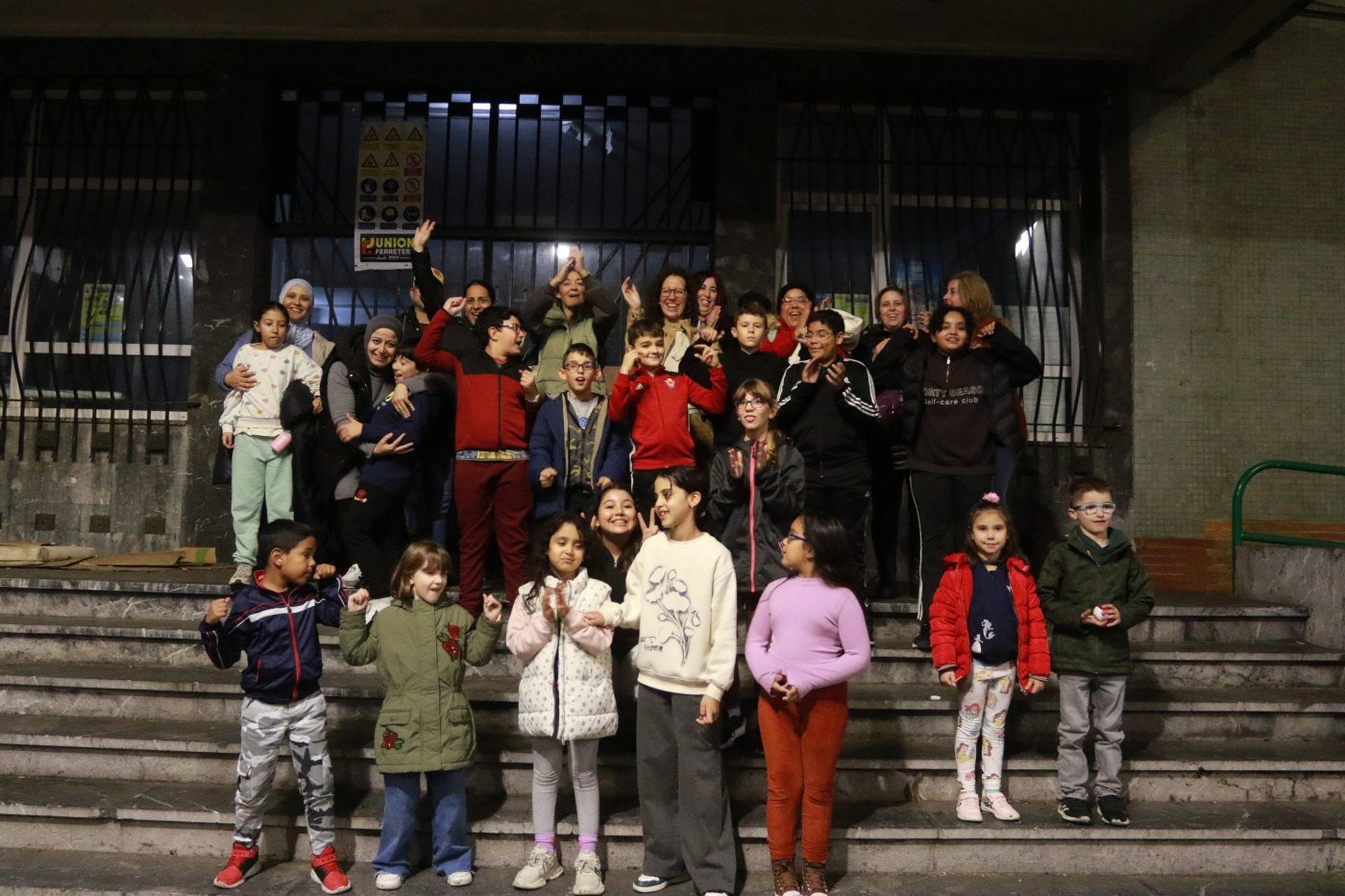 Madres y alumnos del colegio Rey Pelayo celebran la vuelta al centro escolar en enero de 2025 frente a la puerta del mismo.