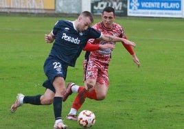 César García, goleador ayer, trata de superar a Ezkurdia en el choque entre el Marino y el Guijuelo.