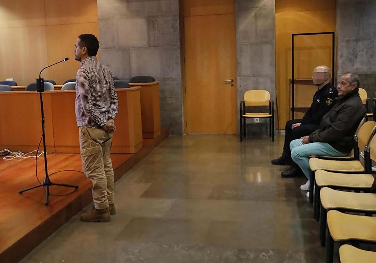 El condenado, sentado junto a un agente de la Policía Nacional, escucha declarar a su exyerno, en el juicio celebrado la pasada semana.