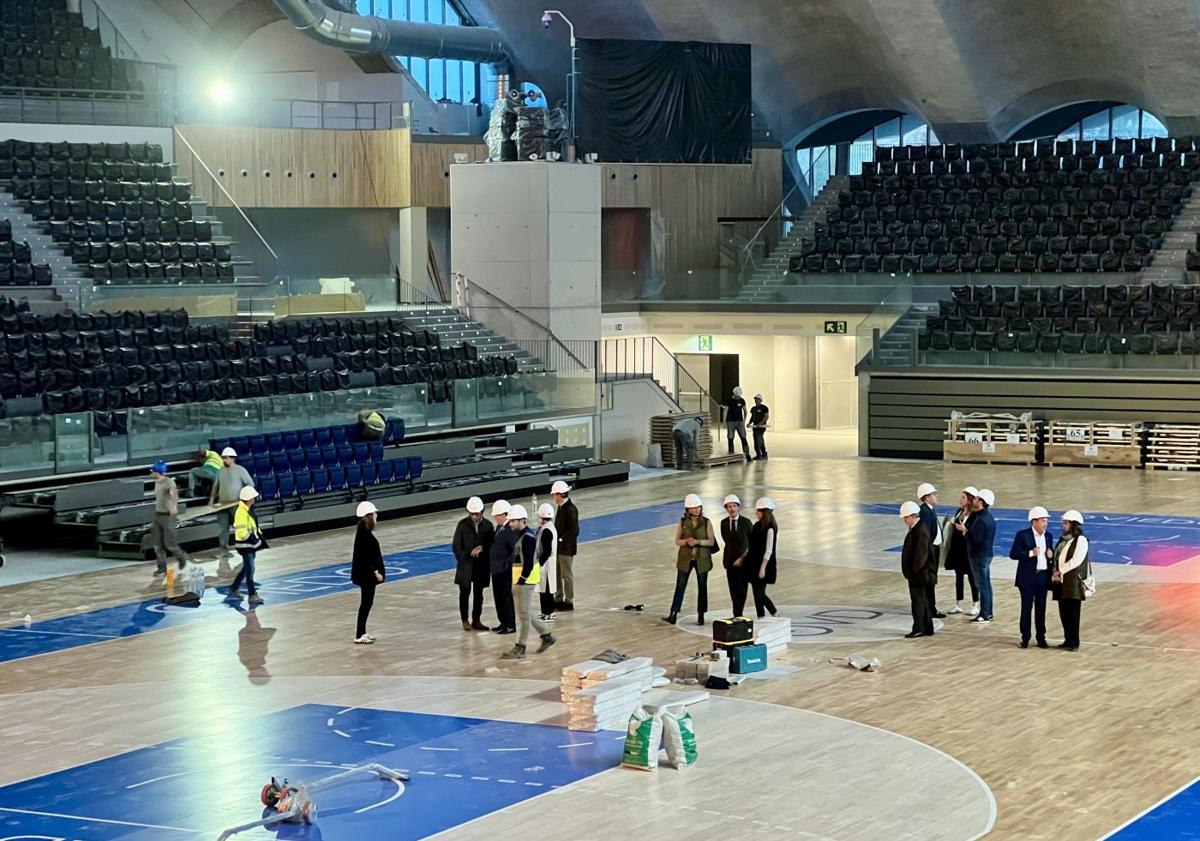 Imagen principal - Arriba, la comitiva municipal en la pista multiusos del Palacio de los Deportes de Oviedo; a la izquierda, la zona exterior del edificio, aún en obras; y a la derecha, Alfredo Canteli (centro) junto al resto de asistentes a la visita.