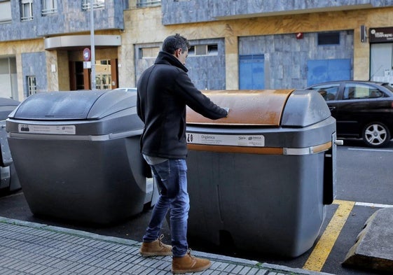 Un vecino de Gijón, junto a un contenedor de recogida de residuos orgánicos.