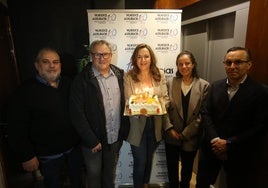 Cristina Álvarez Mendo, directora general de la Vuelta Asturias, en el centro, con una tarta para festejar el centenario.