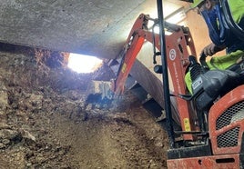 Los operarios, justo cuando abrieron el túnel por la zona del aparcamiento del centro comercial Azabache, en La Fresneda, en Siero.