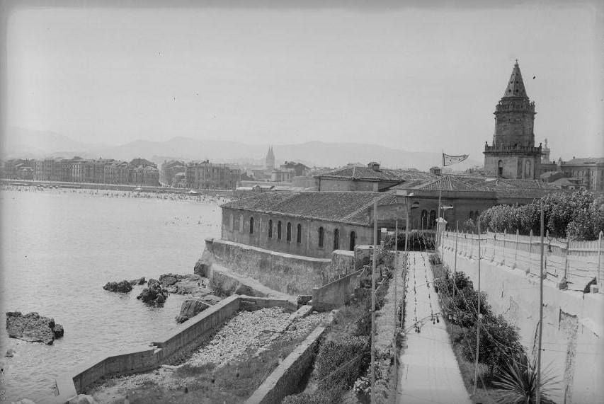 La iglesia de San Pedro cuando estaba pegada al pedrero desde la nueva vía de acceso al Club de Regatas y el dique de la piscina sobre la poza de La Cantábrica. 1928. Instituto del Patrimonio cultural de España.