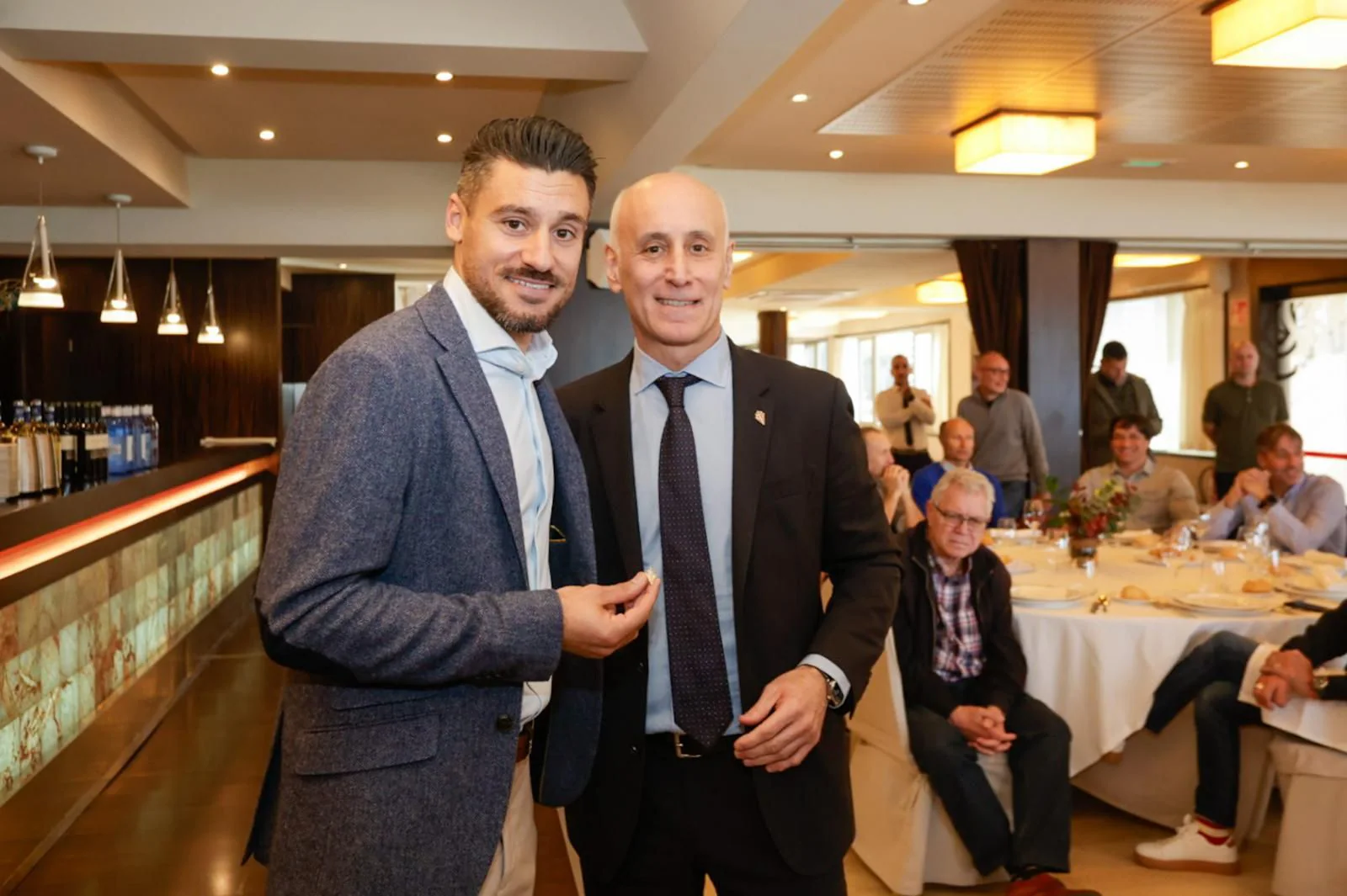 Roberto Canella, con la insignia en la mano, junto a Juan Carlos Ablanedo.