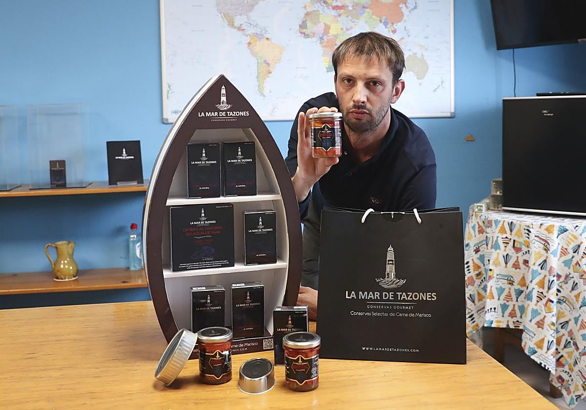 Dimas Noval, con una selección de sus conservas La mar de Tazones en su nave de El Musel.