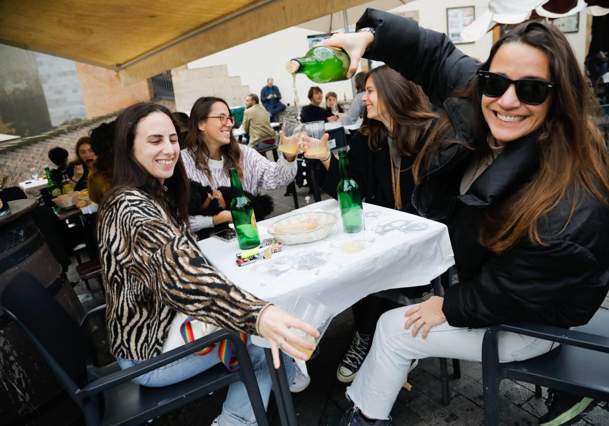 Las gallegas Nathalie Blanco, Inés Aguilar, Carmela Rodríguez y Nuria Gutiérrez beben sidra en una terraza de Gijón.