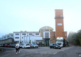 Una mujer pasa por delante del taller de municiones de Trubia, sede en Asturias de Rheinmetall.