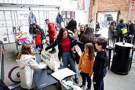 Una madre y dos niños en el puesto de una de las pequeñas participantes del mercadillo navideño del Kuivi de Almacenes Industriales.