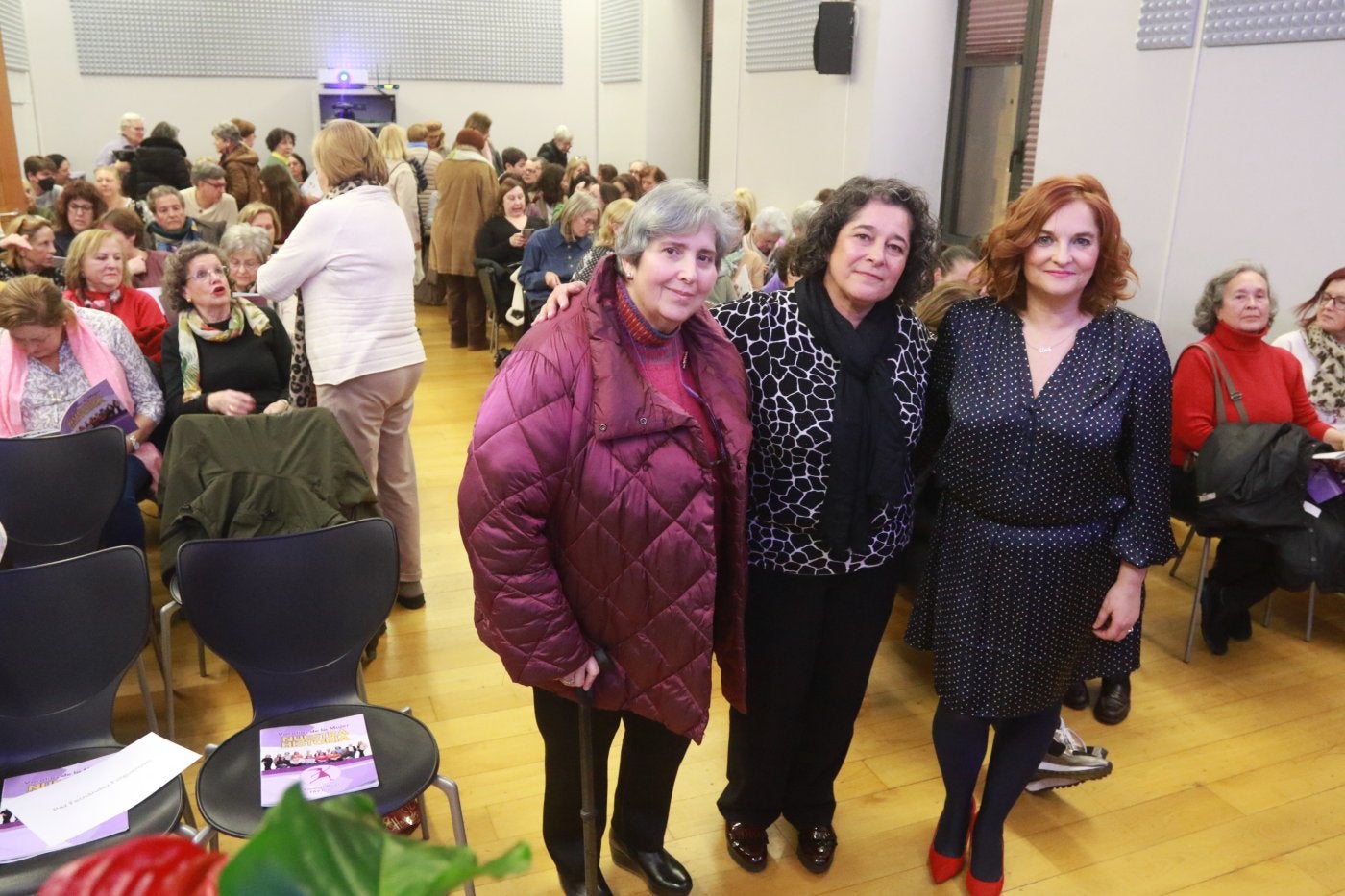 Dulce Gallego, Charo Blanco y Ana Valverde, rodeadas de público en la presentación de la revista 'Vocalías de la Mujer: nuestra historia'.