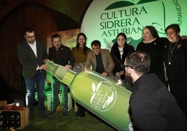 El presidente del Principado de Asturias, Adrián Barbón, con representantes de la cultura asturiana, junto a la botella de sidra que presidió el 'photocall'.