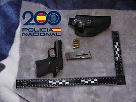 La pistola junto a la munición encontrada en la casa del detenido.